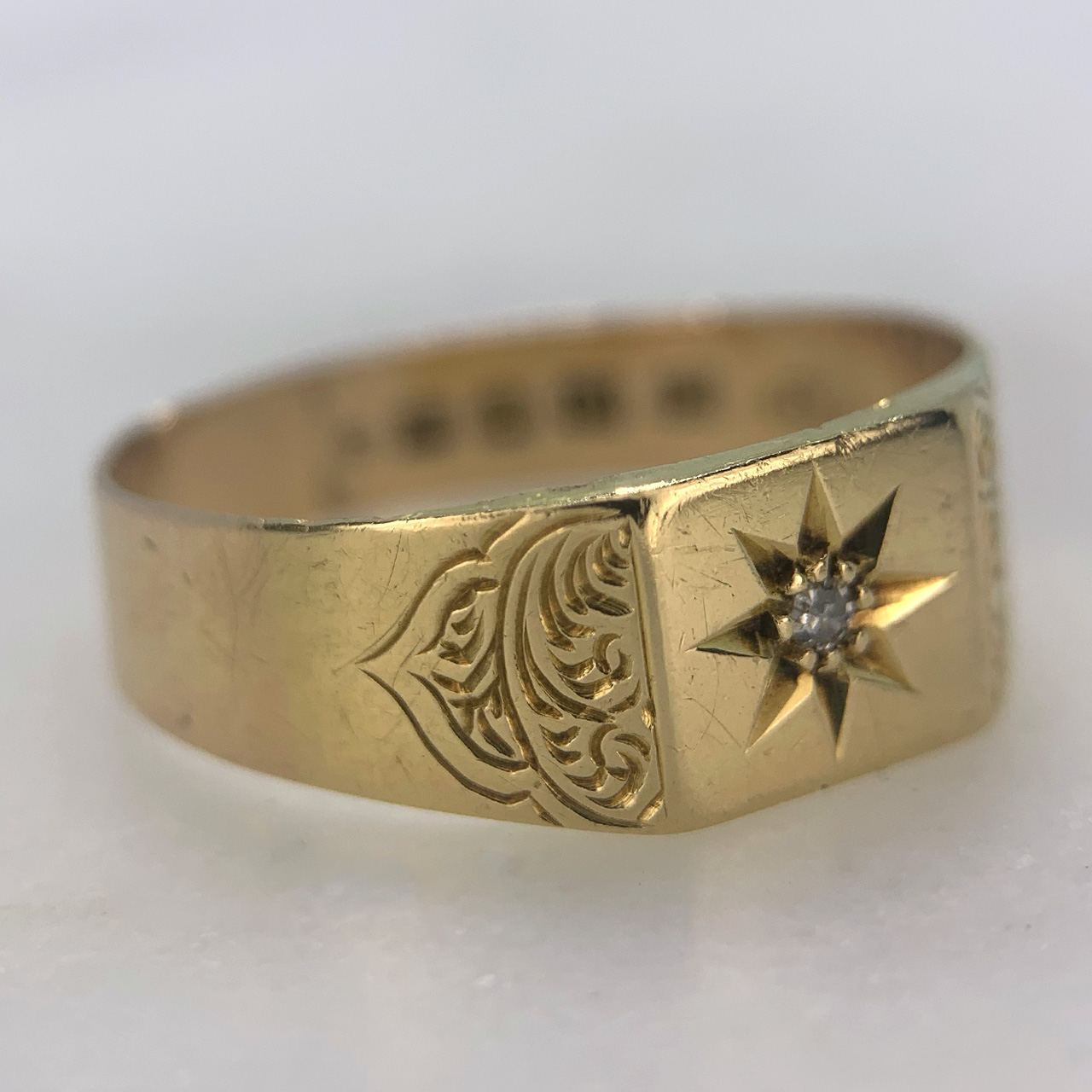 Fabulous Antique Star Set Diamond Signet Ring in 18ct yellow Gold, Hallmarked London (1865). The 1.5 mm diameter diamond is star set in a rectangular top measuring approximately 8 mm x 9 mm. The shoulders are engraved with intricate swirling the rest of the shank is polished. In excellent condition for its age, with minor wear marks. 