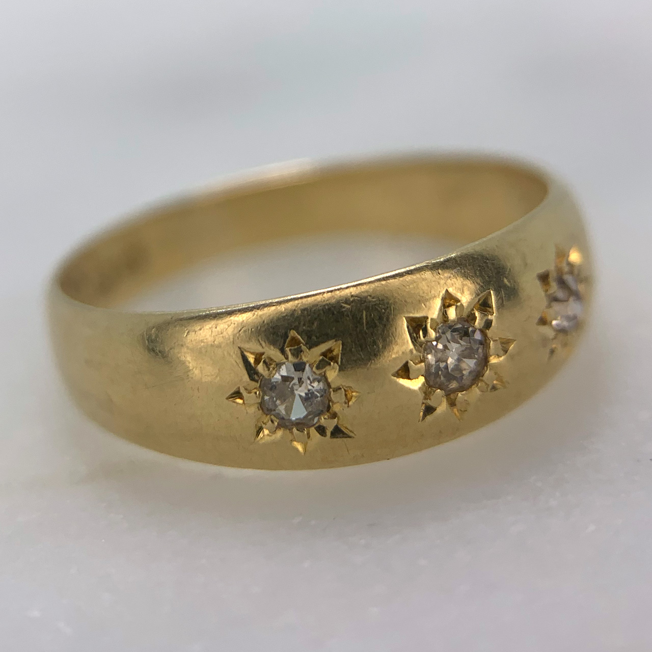 Antique Diamond 3-stone Gypsy Ring in 18ct yellow Gold, Hallmarked Birmingham (1915). This stunning gypsy ring holds three star set diamonds totalling at 0.25 carats of diamond weight. The shank is polished with clear hallmark and makers mark on the inside.