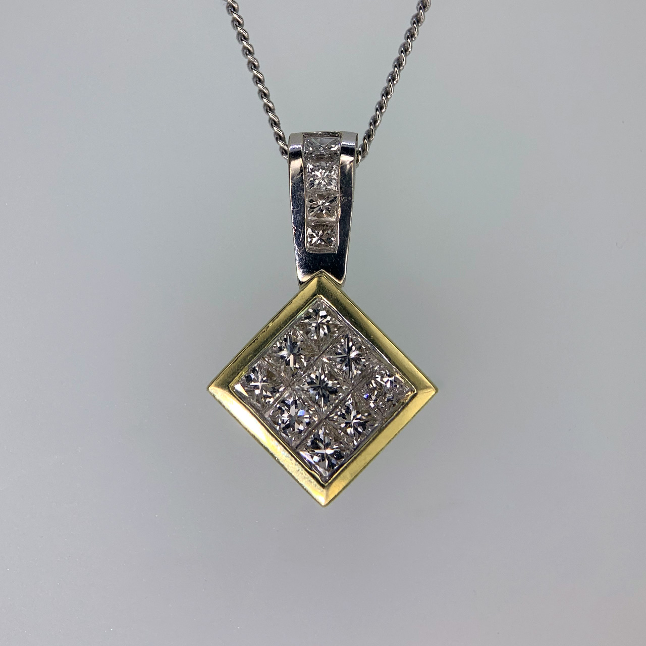 Stunning Pavé Diamond Pendant in 18ct stamped yellow and white Gold. The pendant holds nine princess cut diamonds in a yellow gold drop and four princess cut diamonds in a fixed white gold loop. The total pendant measures approximately 19.2mm x 12mm (including loop). 