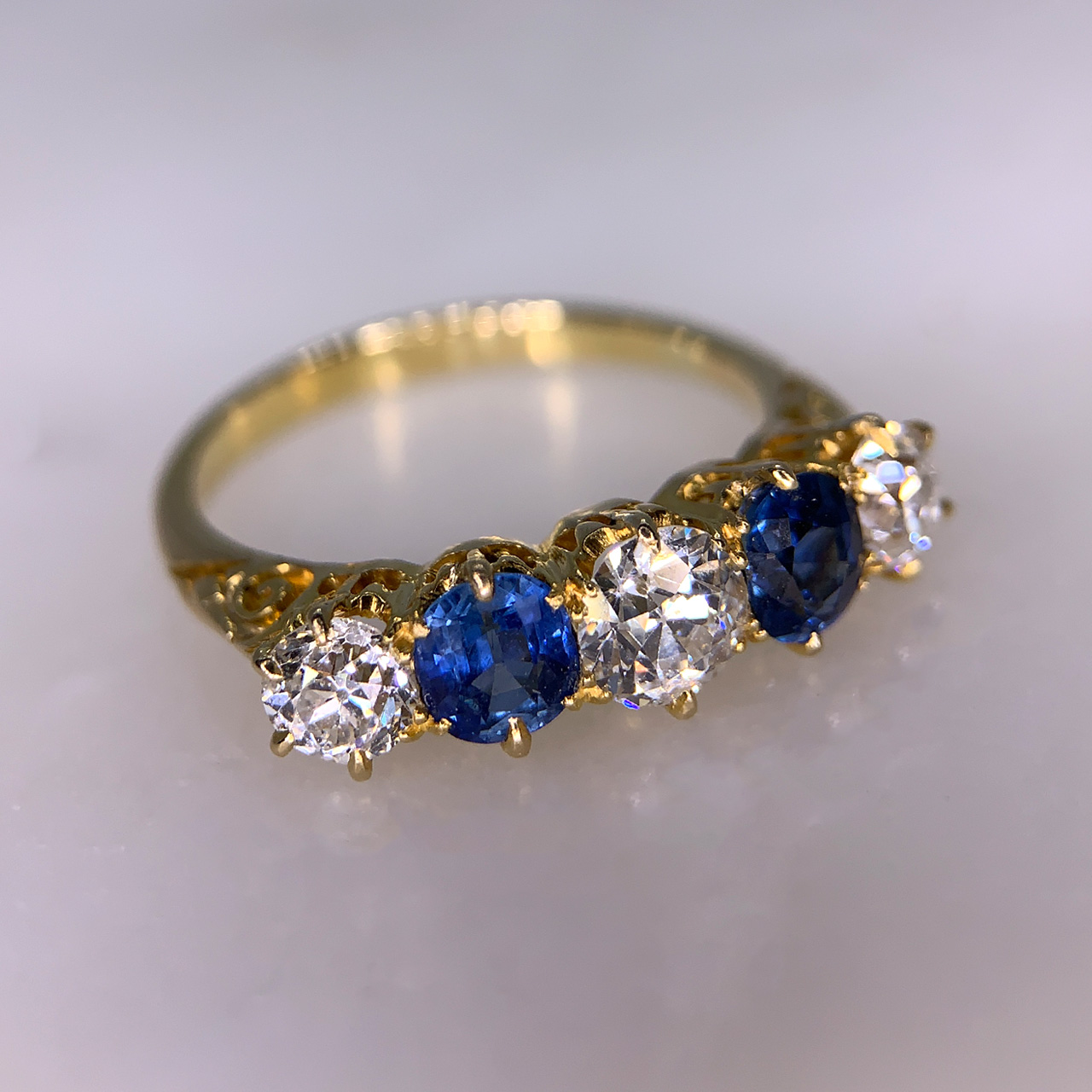 Edwardian Sapphire and Diamond Half Hoop Ring in 18ct Gold tested. This exquisite multi-tone Sapphire and brilliant cut Diamond 5 stone half hoop holds a total of 1 carat of Sapphire and 1.6 carat total diamond weight. All stones are claw set. The head of the ring is approximately 21mm x 6mm and sits within a carved shoulder shank in the most perfect condition.